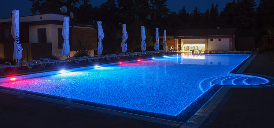 Pool with color-changing LED lights at night