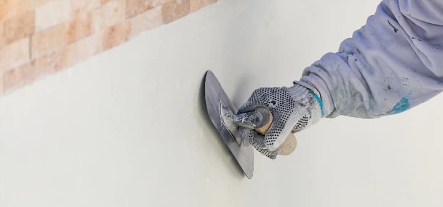 Trowel applying new pool plaster