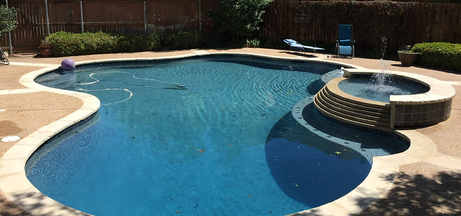 Kidney-shaped pool with raised spa after a remodel
